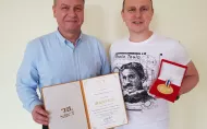 Uśmiechnięci Maciej Pawliczak i Michał Frydrysiak trzymający złoty medal